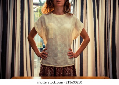 A Young Woman Is Standing By The Curtains Of A Set Of French Doors