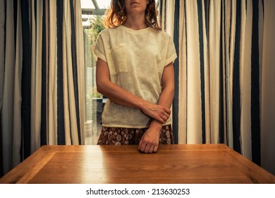 A Young Woman Is Standing By The Curtains Of A Set Of French Doors