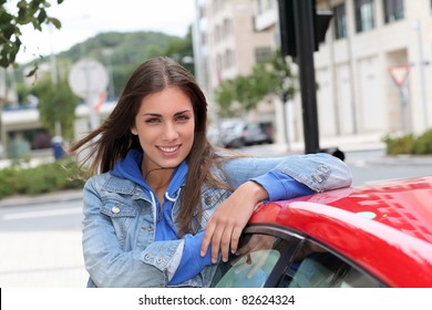 Young Woman Standing By Red Car