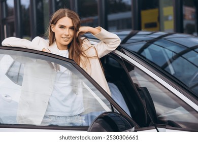 Young woman standing confidently beside her car with a smile, exuding a sense of independence and style. Perfect for concepts of empowerment and modern living. - Powered by Shutterstock