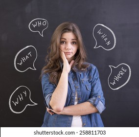 Young woman is standing in front of blackboard background with question.