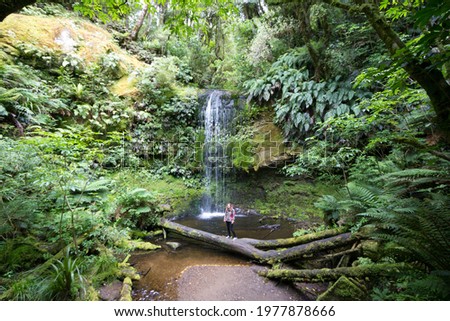  young woman standing in front of charming, Koropuku Falls is found in the western part of Catlins Conservation Park, along the scenic Chaslands Highway