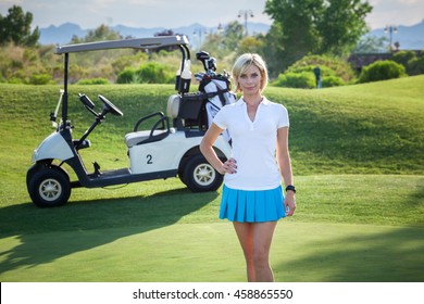 Young woman standing in front of golf cart on golf course with bright blonde hair headshot portrait