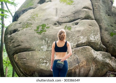 Young Woman Standing In Front Of A Stone Rock Outdoor And Preparing To Climb