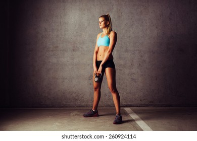 Young woman standing with kettlebell. Cross workout - Powered by Shutterstock