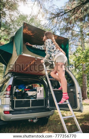 Similar – Image, Stock Photo Woman standing in ladder opening tent over car