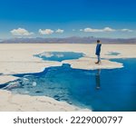 Young woman  standing near the water in the Salinas Grandes salt flats in Argentina. Salt desert in the Salta Province, Argentina.