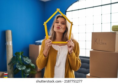 Young woman standing at new home looking at the camera blowing a kiss being lovely and sexy. love expression.  - Shutterstock ID 2187751277