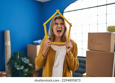Young woman standing at new home angry and mad screaming frustrated and furious, shouting with anger. rage and aggressive concept.  - Shutterstock ID 2294895873