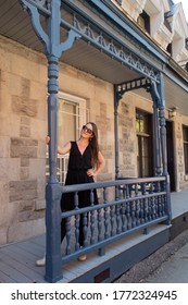 Young Woman Standing On The Front Porch Of A Typical House In Montreal, Canada