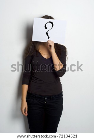 Young woman standing with question mark on board