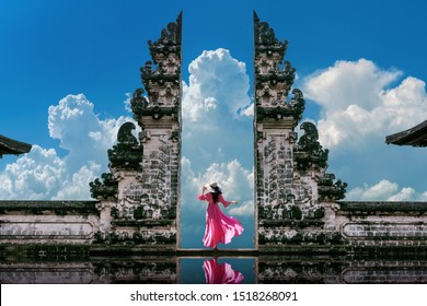 Young woman standing in temple gates at Lempuyang Luhur temple in Bali, Indonesia. Vintage tone.