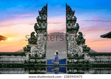 Young woman standing in temple gates at Lempuyang Luhur temple in Bali, Indonesia.