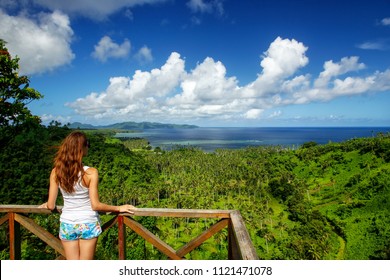 Young woman standing at the viewpoint in Bouma National Heritage Park on Taveuni Island, Fiji. Taveuni is the third largest island in Fiji.
