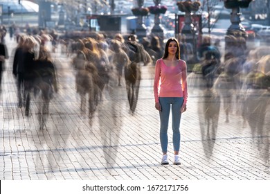 The young woman stands in the middle of crowded street