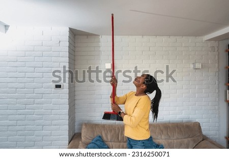 Young woman stares at the ceiling and yells because a neighbor upstairs is having a party with loud music or renovating an apartment and workers are drilling with heavy tools. Noise pollution concept