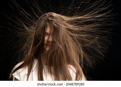 Young woman with static long hair up, on black background. 