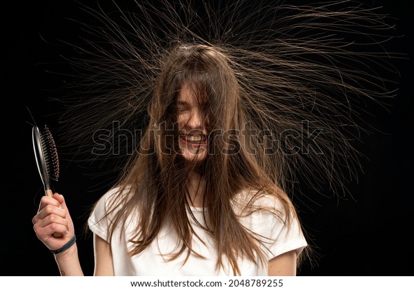 Young woman with static long hair up, on black\
background. 