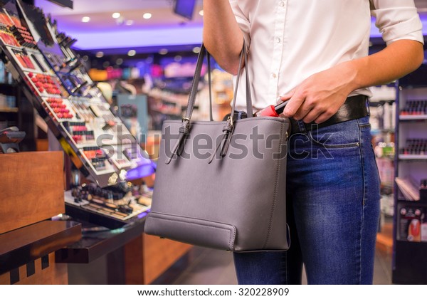 Young woman is stealing\
goods in a shop