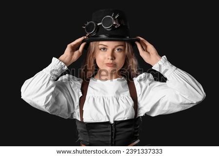 Young woman with steampunk goggles on dark background