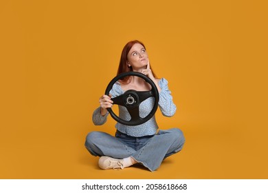 Young Woman With Steering Wheel On Yellow Background