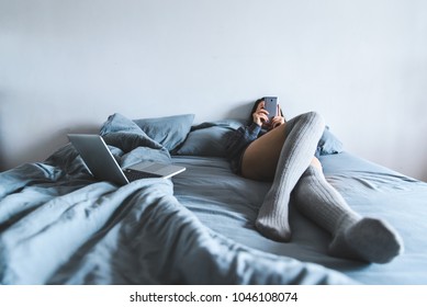 young woman in stocking lay on bed and chat by phone. - Shutterstock ID 1046108074
