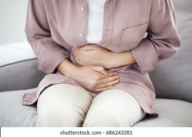 Young woman with stomach pain - Shutterstock ID 686243281