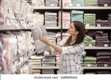 A Young Woman In A Store Chooses Textiles. The Concept Of Shopping For A Home.