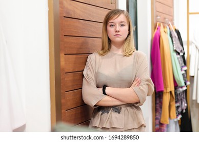 Young Woman At The Store As A Shop Assistant. Sad Girl Near  Dressing Room. Clothes Choice. Shopping Concept With Copy Space  