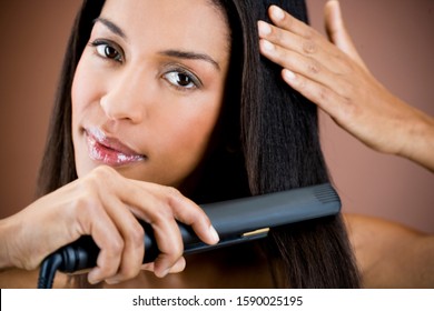 A Young Woman Straightening Her Hair