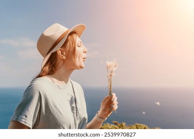 Young Woman in a Straw Hat Blowing Dandelion Seeds - Powered by Shutterstock