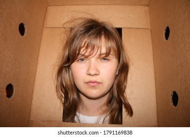 Young Woman Stressing Out About Moving With Her Head Stuck In One Of Her Moving Boxes