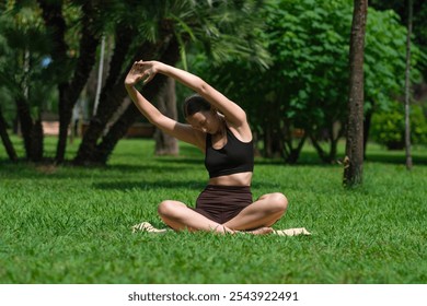 Young woman stretches on mat in park, practicing yoga under warm sun. Serene environment enhances her focus on relaxation and wellness during sunny day - Powered by Shutterstock