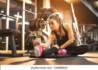 Young Woman Stretching Legs In Gym.