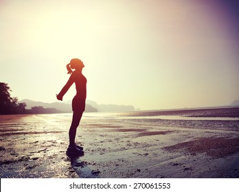  young woman stretching on  sunrise beach 