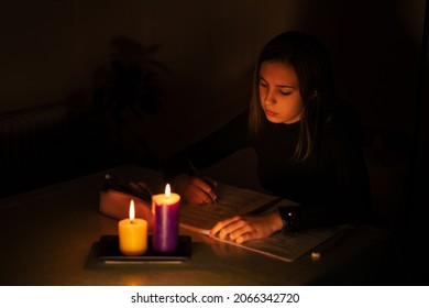 Young Woman Studying By Candlelight. Blackout Concept, Power Cut