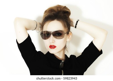 young woman in stylish sunglasses on a bright background