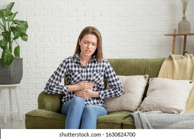 Young Woman Suffering From Abdominal Pain At Home