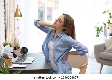 Young Woman Suffering From Back Pain In Office