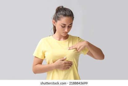 Young Woman Suffering From Breast Pain On Grey Background