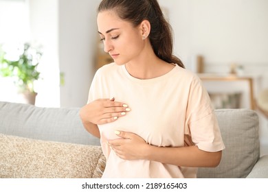 Young Woman Suffering From Breast Pain At Home