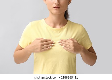 Young Woman Suffering From Breast Pain On Grey Background, Closeup