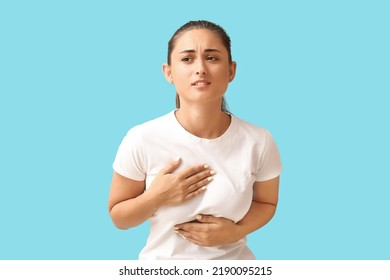 Young Woman Suffering From Breast Pain On Blue Background