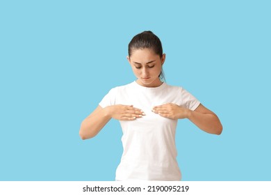 Young Woman Suffering From Breast Pain On Blue Background