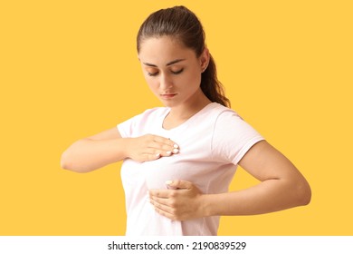 Young Woman Suffering From Breast Pain On Yellow Background