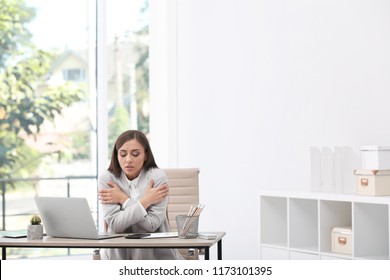 Young Woman Suffering From Cold In Office. Air Conditioner Malfunction