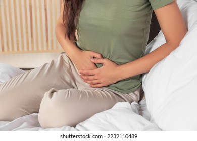 Young woman suffering from cystitis on bed indoors, closeup - Shutterstock ID 2232110489