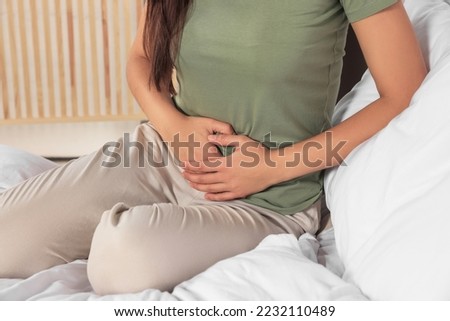Young woman suffering from cystitis on bed indoors, closeup Сток-фото © 