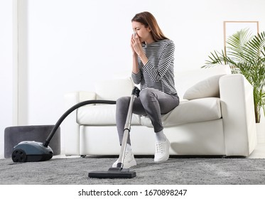 Young Woman Suffering From Dust Allergy While Vacuuming House