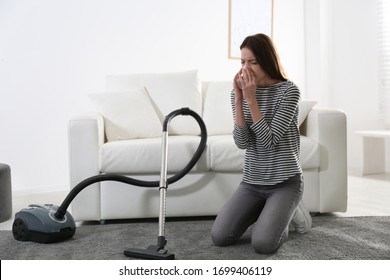 Young Woman Suffering From Dust Allergy While Vacuuming House